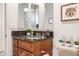 Bathroom vanity with dark granite countertop and wood cabinets below, with framed mirror above at 27913 N Walnut Creek Rd, Rio Verde, AZ 85263