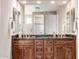 Well-lit bathroom showcasing dual sinks, granite countertops and wooden cabinets at 27913 N Walnut Creek Rd, Rio Verde, AZ 85263