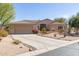 Charming beige home featuring a two-car garage, desert landscaping, and a welcoming entrance at 27913 N Walnut Creek Rd, Rio Verde, AZ 85263