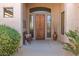 Inviting front porch with a wooden door, side windows, bench, and desert landscaping at 27913 N Walnut Creek Rd, Rio Verde, AZ 85263