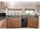 Kitchen counter with granite countertops, wooden cabinets, and stainless-steel dishwasher at 27913 N Walnut Creek Rd, Rio Verde, AZ 85263