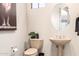 Powder room with a pedestal sink, decorative mirror and stylish decor at 27913 N Walnut Creek Rd, Rio Verde, AZ 85263