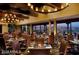 Elegant restaurant with scenic views, beautifully set tables, and warm lighting for a memorable dining experience at 27913 N Walnut Creek Rd, Rio Verde, AZ 85263