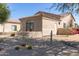 Beige home featuring desert landscaping with rocks, cacti, and colorful flowering bushes at 27913 N Walnut Creek Rd, Rio Verde, AZ 85263