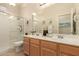 Bright bathroom boasts a double vanity, tiled floors, and a glass-enclosed shower at 2909 N 111Th Dr, Avondale, AZ 85392