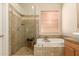 Bathroom with a glass shower, soaking tub, and decorative tile, creating a relaxing retreat at 2909 N 111Th Dr, Avondale, AZ 85392