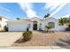 Charming single-story home showcasing desert landscaping, a tiled roof, and a clean white facade at 2909 N 111Th Dr, Avondale, AZ 85392