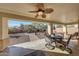 Covered back patio with ceiling fan and outdoor dining set overlooking water feature at 29681 W Amelia Ave, Buckeye, AZ 85396