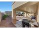 Inviting covered back patio with outdoor kitchen, seating, and desert landscaping at 29681 W Amelia Ave, Buckeye, AZ 85396