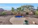 Backyard with a charming rock waterfall feature and desert landscaping at 29681 W Amelia Ave, Buckeye, AZ 85396