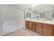 Well-lit bathroom with a double vanity, sliding door closet, and tile flooring at 29681 W Amelia Ave, Buckeye, AZ 85396