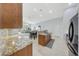 Bright kitchen featuring wood cabinetry, mosaic backsplash, granite countertops, and stainless steel appliances at 29681 W Amelia Ave, Buckeye, AZ 85396