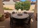 Covered brick patio with outdoor seating area and lush landscaped yard at 3212 E Constance Way, Phoenix, AZ 85042