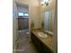 Well-lit bathroom with a large mirror, tan vanity, tiled shower and flooring at 3212 E Constance Way, Phoenix, AZ 85042