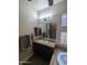 Bright bathroom featuring a white sink, dark wood cabinets, a large mirror, and a partial view of the bathtub at 3212 E Constance Way, Phoenix, AZ 85042