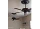 Dual dark-toned ceiling fans with lighting fixtures, complementing the neutral wall color in the house at 3212 E Constance Way, Phoenix, AZ 85042