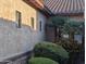 Close up of an exterior wall with tan stucco, dark trim windows, and desert landscaping at 3212 E Constance Way, Phoenix, AZ 85042