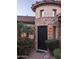 Close up of a wrought iron front door framed by stone and lush desert landscaping at 3212 E Constance Way, Phoenix, AZ 85042