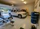 Well-organized garage featuring epoxy flooring, car, and ample space for both vehicle storage and a home gym setup at 3212 E Constance Way, Phoenix, AZ 85042