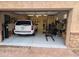 Attached garage showcasing epoxy flooring, a car, workout area, storage, and organized layout, ideal for car or fitness enthusiasts at 3212 E Constance Way, Phoenix, AZ 85042