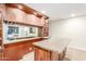 Bar area featuring wooden cabinets, a granite countertop, and a mirrored backsplash at 3464 E Dartmouth St, Mesa, AZ 85213