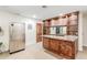 Bar area featuring wooden cabinets, granite countertops, and a stainless steel refrigerator at 3464 E Dartmouth St, Mesa, AZ 85213