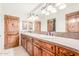 Bathroom with double sinks, a large mirror, wooden cabinets, and tiled countertops at 3464 E Dartmouth St, Mesa, AZ 85213