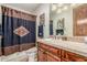 Neutral bathroom featuring a vanity with a sink, a shower, and patterned tiles at 3464 E Dartmouth St, Mesa, AZ 85213