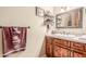 Powder room with a decorative mirror, wood cabinetry, and a tiled countertop at 3464 E Dartmouth St, Mesa, AZ 85213
