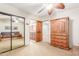 Bedroom featuring a mirrored closet, adjacent bathroom, and wooden storage cabinet at 3464 E Dartmouth St, Mesa, AZ 85213