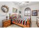 Cozy bedroom with a wood bed frame, neutral walls, decorative shutters, and classic wood furniture at 3464 E Dartmouth St, Mesa, AZ 85213