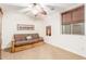 Comfortable bedroom with a ceiling fan, window with shades, and a brown futon couch at 3464 E Dartmouth St, Mesa, AZ 85213