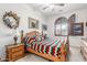 Cozy bedroom with a wood bed frame, neutral walls, decorative shutters, and classic wood furniture at 3464 E Dartmouth St, Mesa, AZ 85213