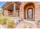 Charming front entrance with a stone archway, decorative glass door, and landscaped surroundings at 3464 E Dartmouth St, Mesa, AZ 85213