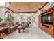 Well-lit living room featuring comfortable seating, arched windows, and a custom entertainment center at 3464 E Dartmouth St, Mesa, AZ 85213