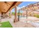 A covered patio overlooks the pool area, complete with palm trees and ample seating, providing a luxurious outdoor experience at 3464 E Dartmouth St, Mesa, AZ 85213