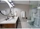 Bright bathroom showcasing a glass shower with marble tile, and vanity with dual sinks and modern mirrors at 350 N 9Th St, Coolidge, AZ 85128