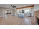 Open-concept living area featuring modern kitchen with island seating, wood beam accent, and brick fireplace at 350 N 9Th St, Coolidge, AZ 85128