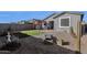 Relaxing backyard featuring a covered patio, gravel, and a green patch of artificial turf at 36243 W San Clemente Ave, Maricopa, AZ 85138