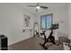 Bright bedroom featuring workout equipment, neutral walls and carpet, and shuttered windows at 36243 W San Clemente Ave, Maricopa, AZ 85138