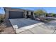 Long concrete driveway leading to a two-car garage with manicured landscaping and hardscape at 36243 W San Clemente Ave, Maricopa, AZ 85138