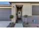 Inviting front entry with stylish door, wreath accent, and manicured potted topiary at 36243 W San Clemente Ave, Maricopa, AZ 85138