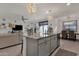 Stylish kitchen island boasts granite countertops and modern lighting, connecting the living and dining areas at 36243 W San Clemente Ave, Maricopa, AZ 85138