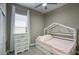 This charming bedroom offers a cozy retreat with plush pink bedding and soft natural light from the window at 40789 W Shaver Dr, Maricopa, AZ 85138