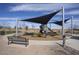 This inclusive playground features a shaded play area with swings and slides, surrounded by benches and walking paths at 40789 W Shaver Dr, Maricopa, AZ 85138