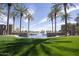 This picturesque pond features water fountains and is surrounded by lush greenery and tall palm trees at 40789 W Shaver Dr, Maricopa, AZ 85138