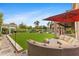 A backyard with manicured lawn, covered patio and desert landscaping, complete with a fire pit at 4297 S Marion Pl, Chandler, AZ 85249