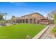 Expansive backyard features a large manicured lawn, a covered patio, desert landscaping, and a water feature at 4297 S Marion Pl, Chandler, AZ 85249