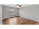 Empty bedroom with a ceiling fan, plantation shutters, neutral paint, and wood floors at 4297 S Marion Pl, Chandler, AZ 85249