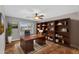 Home office with built-in bookshelves, dark wood desk, ceiling fan, and wood floors at 4297 S Marion Pl, Chandler, AZ 85249